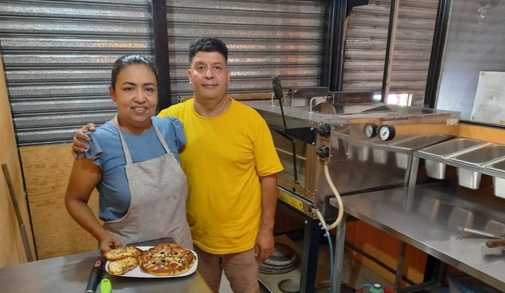 Emprendedores mostrando sus productos artesanales en su negocio.