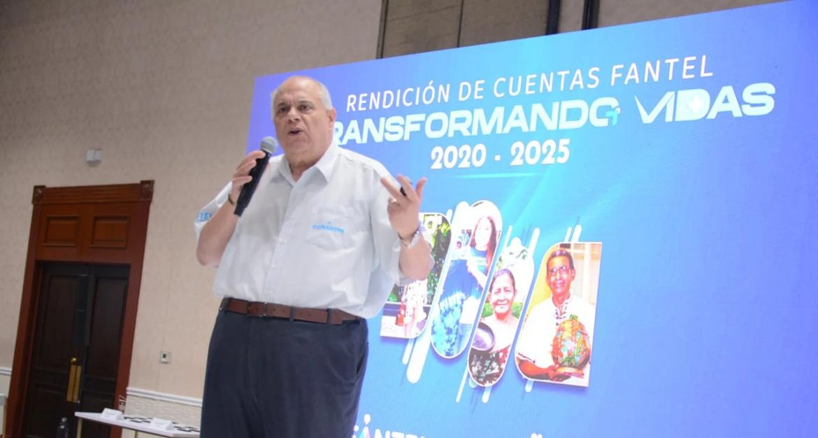 Hombre mayor con micrófono ofrece una presentación en un evento institucional, con un fondo azul que dice 'Rendición de Cuentas FANTEL 2020–2025: Transformando Vidas'. En la pantalla se muestran fotografías de personas beneficiarias. El presentador viste camisa blanca con el logo de CONAMYPE."