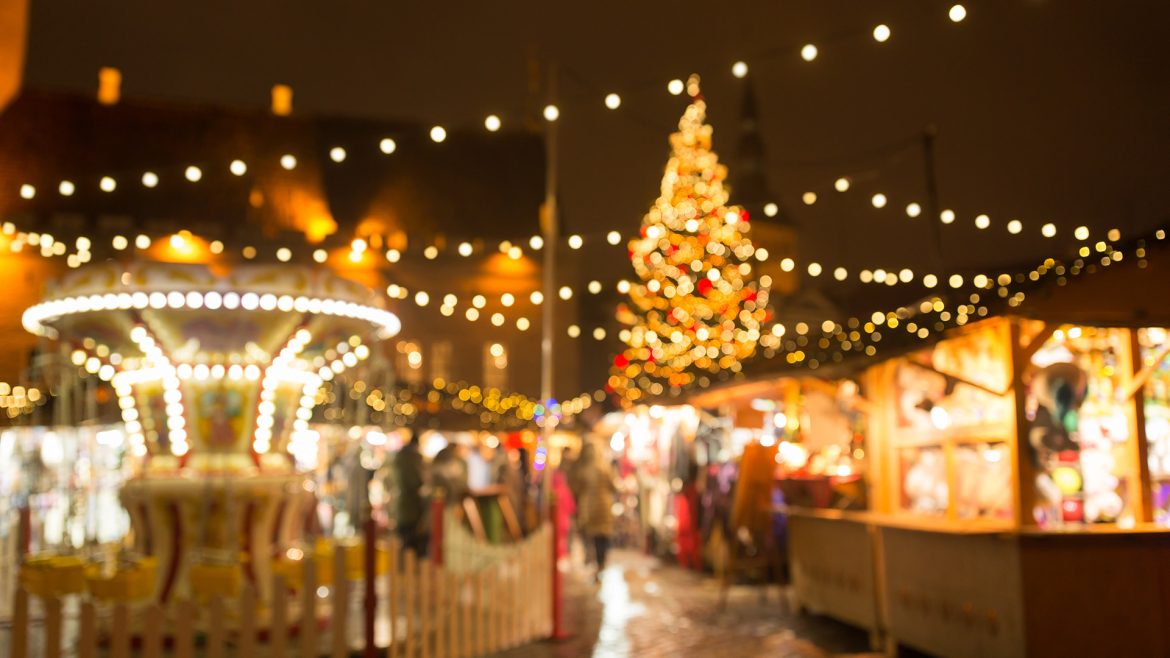 Feria navideña con luces, árbol de Navidad y puestos de venta iluminados, representando el aumento de actividad comercial y oportunidades para las MYPE durante la temporada festiva.