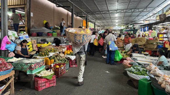 Comerciantes y clientes en mercado popular, reflejando economía informal y baja inversión productiva en mipymes salvadoreñas