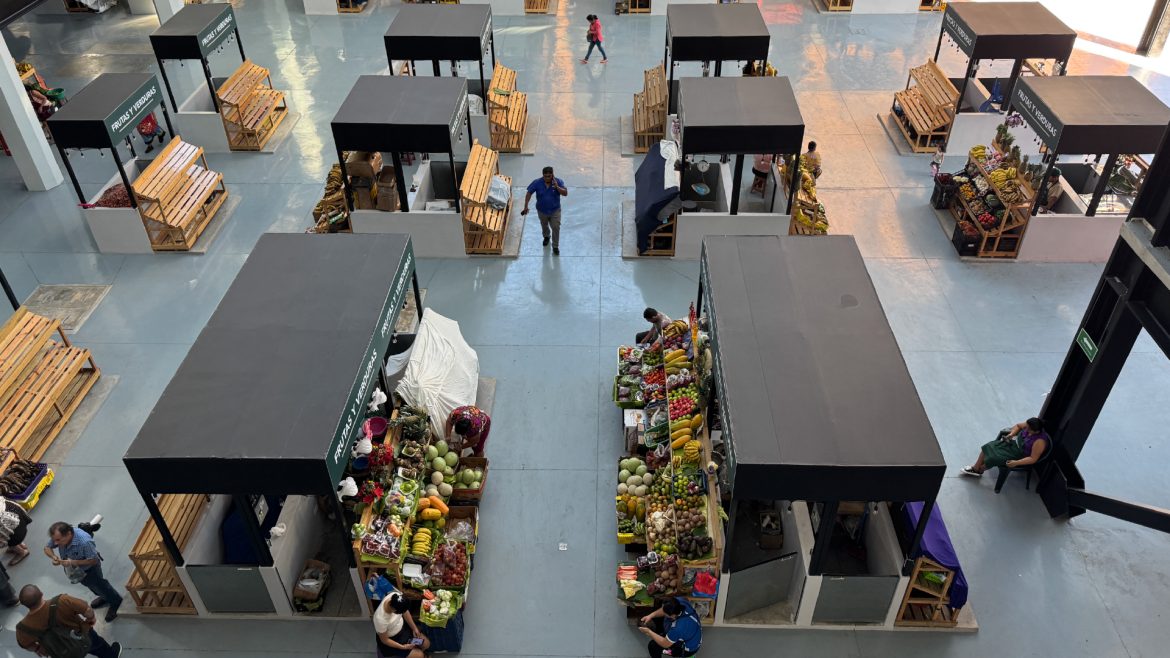 Puestos de frutas y verduras en un mercado local con pequeños comerciantes MYPE ofreciendo productos frescos